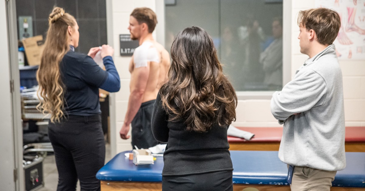 KHSC - KansasCOM medical students look on as the Witchita Thunder's athletic trainer works with a hockey player.