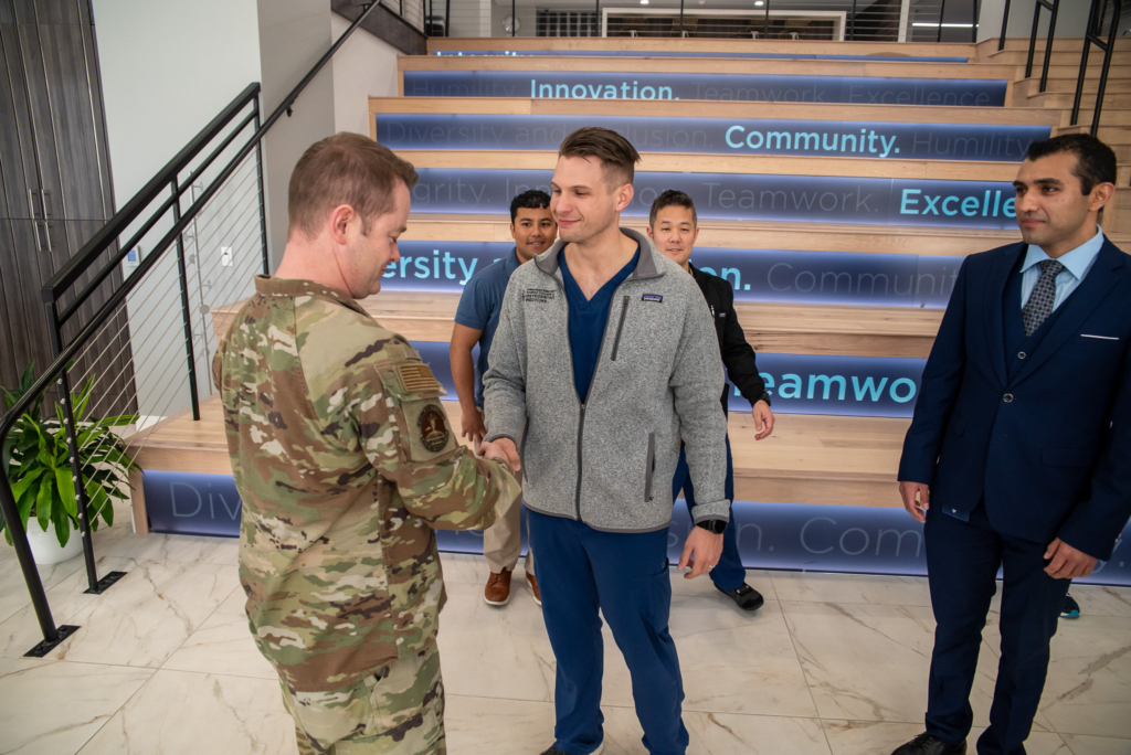 Student Doctor Joseph Wohler presents a challenge coin to Lt Col Mike Zeola, MD, during a recent event on campus. Dr. Zeola, an esteemed MD in psychiatry, serves as the Commander of the 22d Operational Medical Readiness Squadron at McConnell Air Force Base.