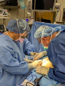 Two doctors perform surgery on a patient.